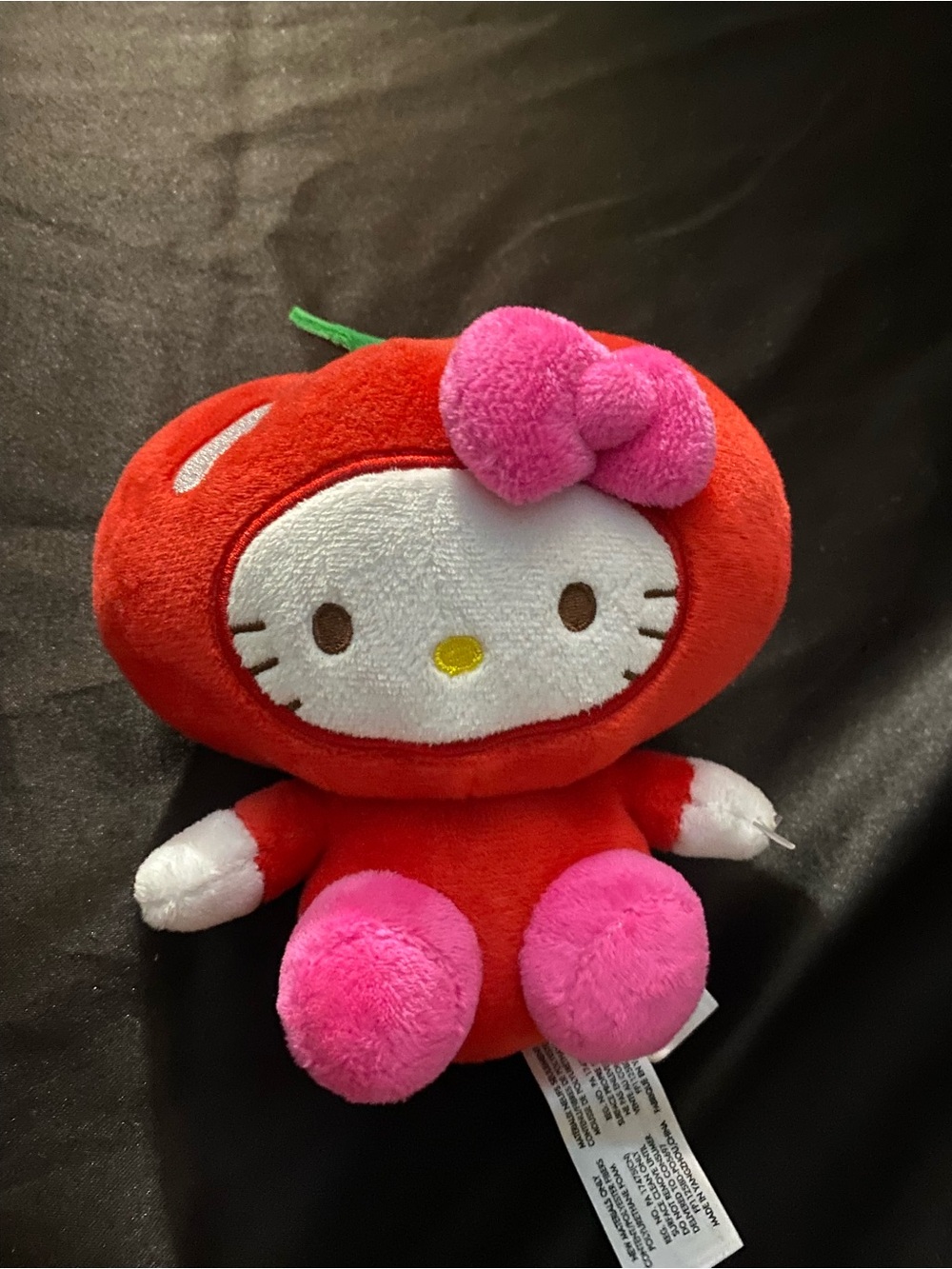 Hello kitty dressed in a red fruit custome